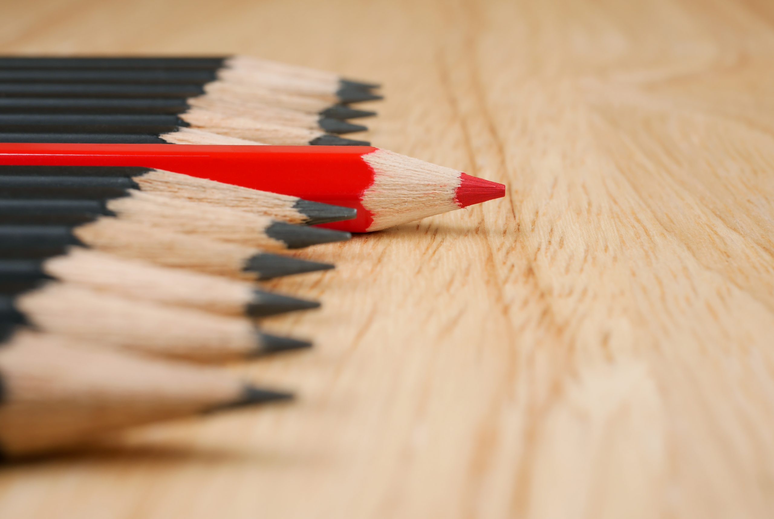 Red pencil standout from black pencil, leadership business concept
